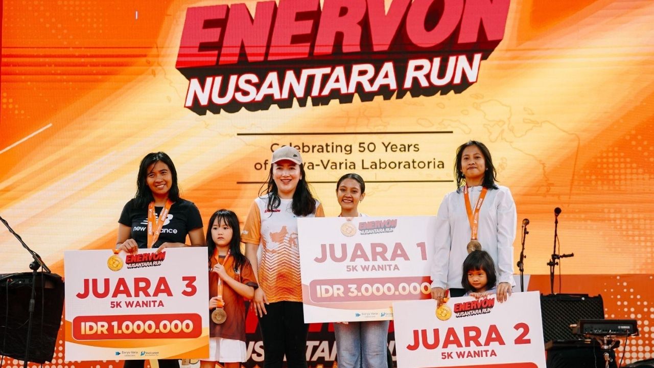 Peserta memegang medali finisher dengan senyum kemenangan